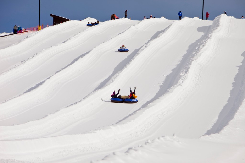 Snow tubers racing down the groomed lanes at Frisco Adventure Park
