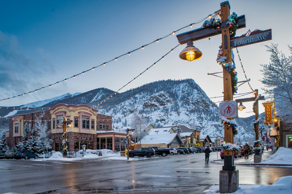 Snowy mountains and string lights seen from Frisco's Main Street in the wintertime
