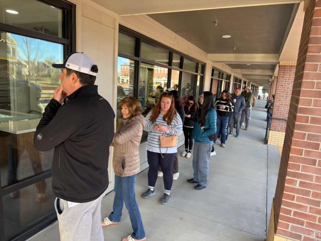 a line of customers waiting for pastry