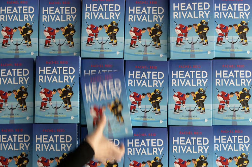A person takes a copy of the popular book Heated Rivalry