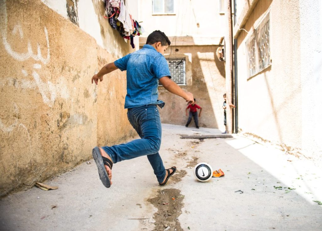 A child is about to kick a soccer ball