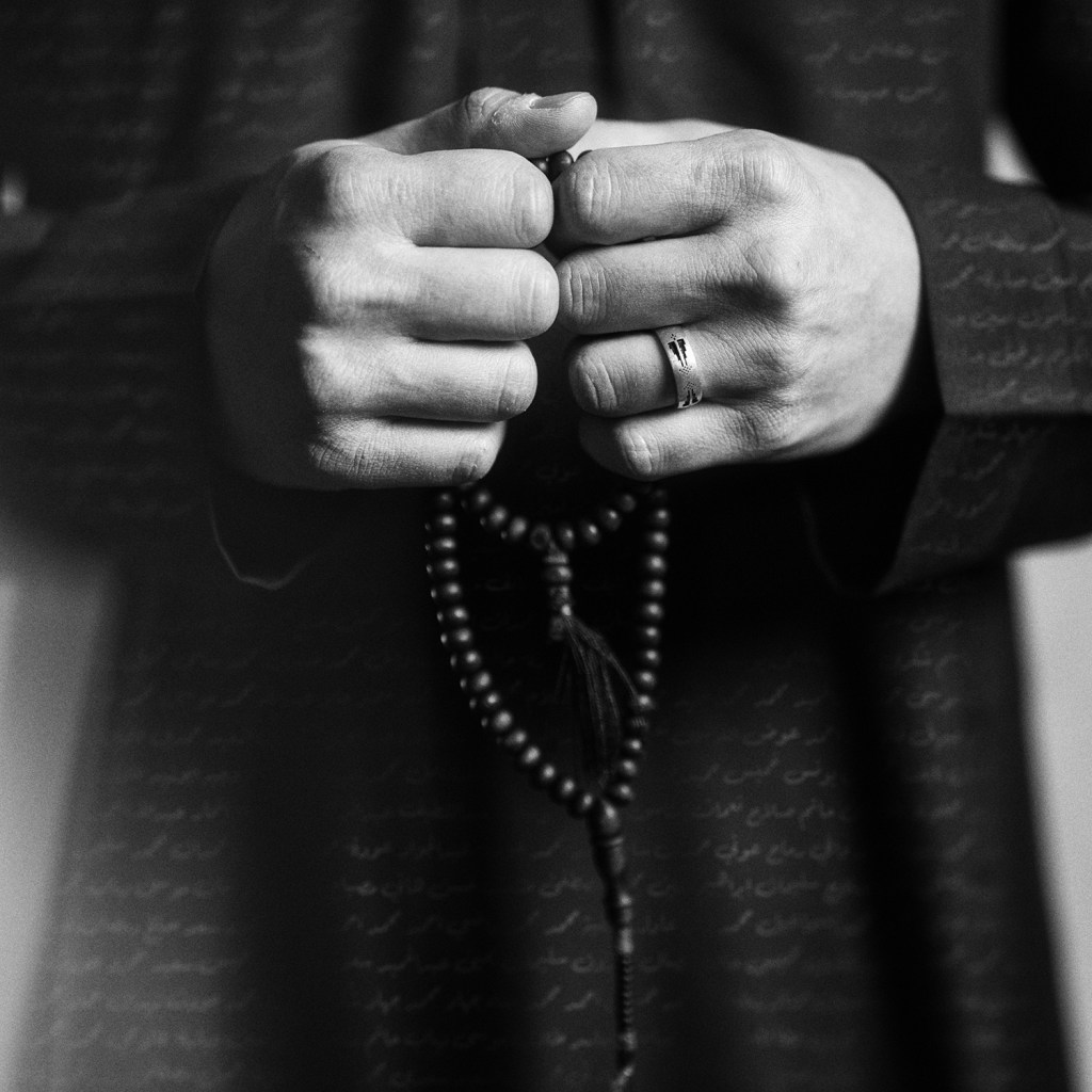 A black and white photo of a hands holding beads