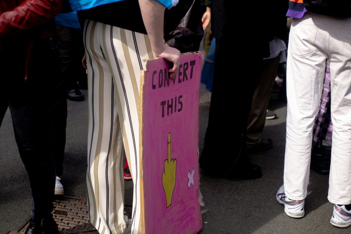 A protester holds a sign opposing conversion therapy