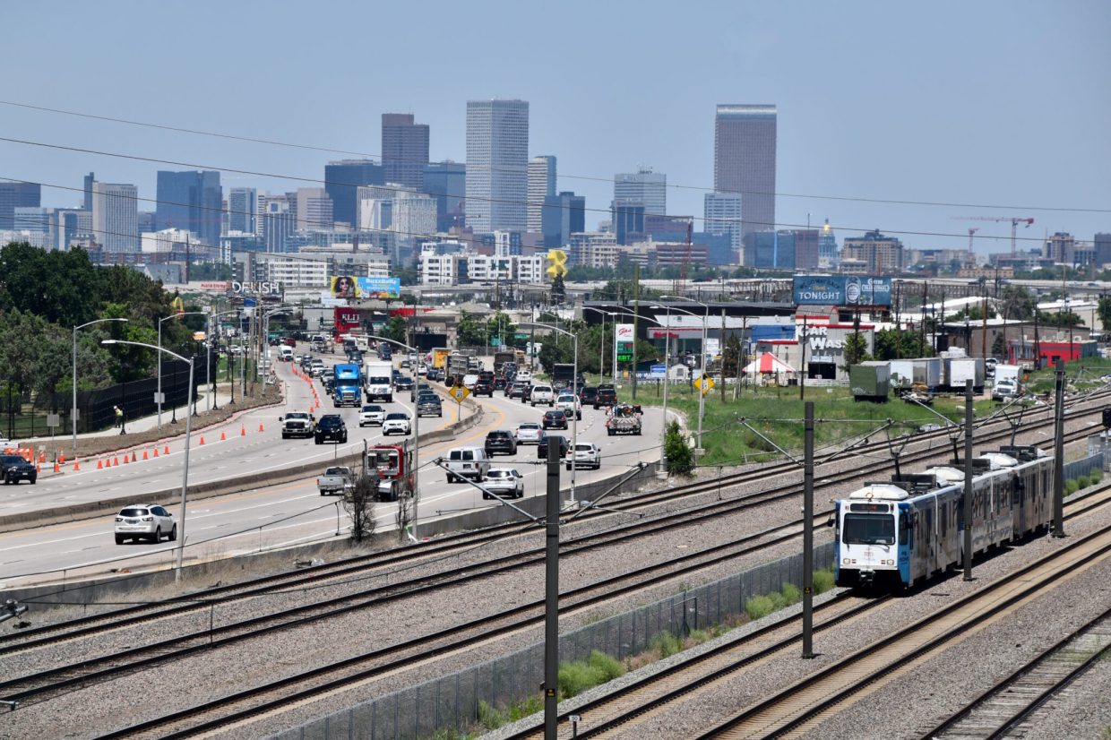 A view of the Denver skyline as a light rail car goes by on Santa Fe Avenue.