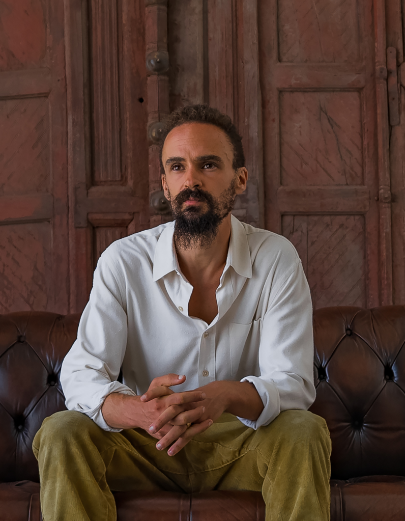 beared man in white shirt sitting