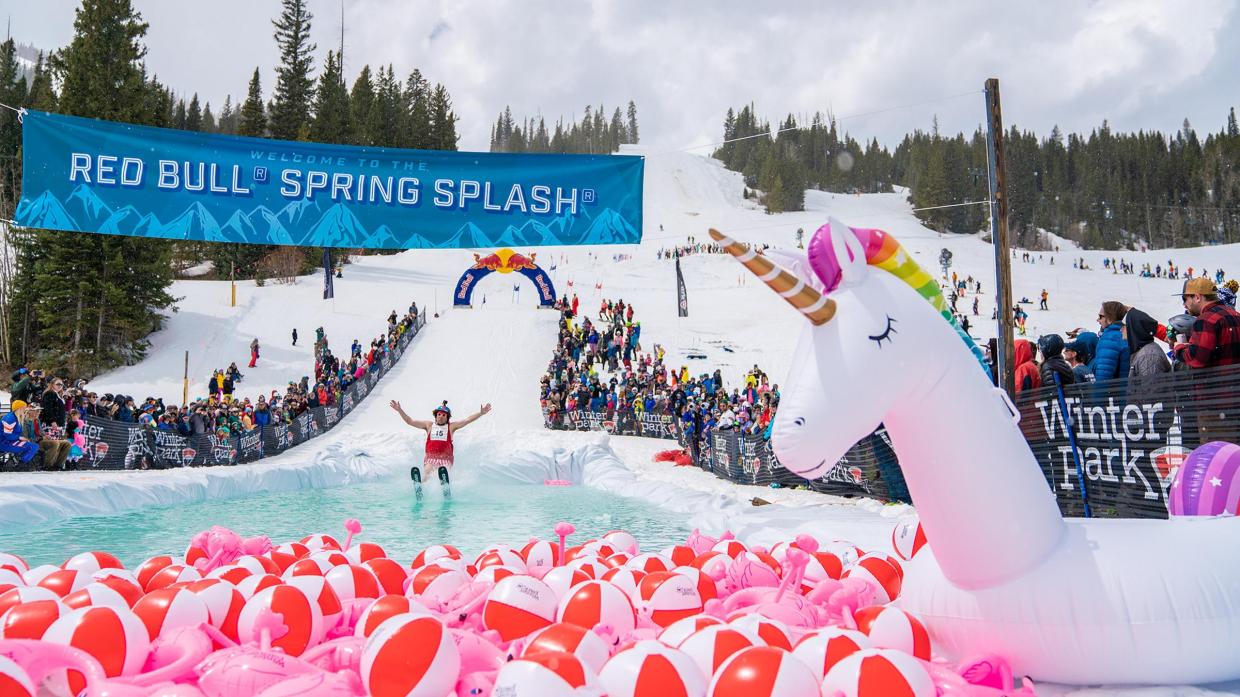 man skiing into pool of water with balloons