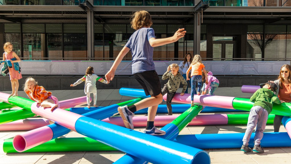 Kids play on a large-scale abstract art installation.