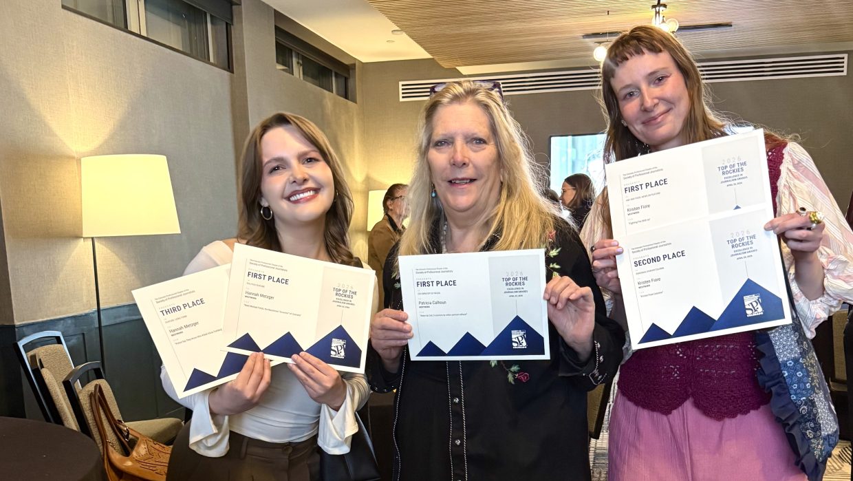 Three Westword staff members hold up paper "Top of the Rockies" awards at the ceremony on April 25, 2026. Staff writer Hannah Metzger is on the left, editor in chief Patricia Calhoun is in the middle, and culture editor Kristen Fiore is on the right.