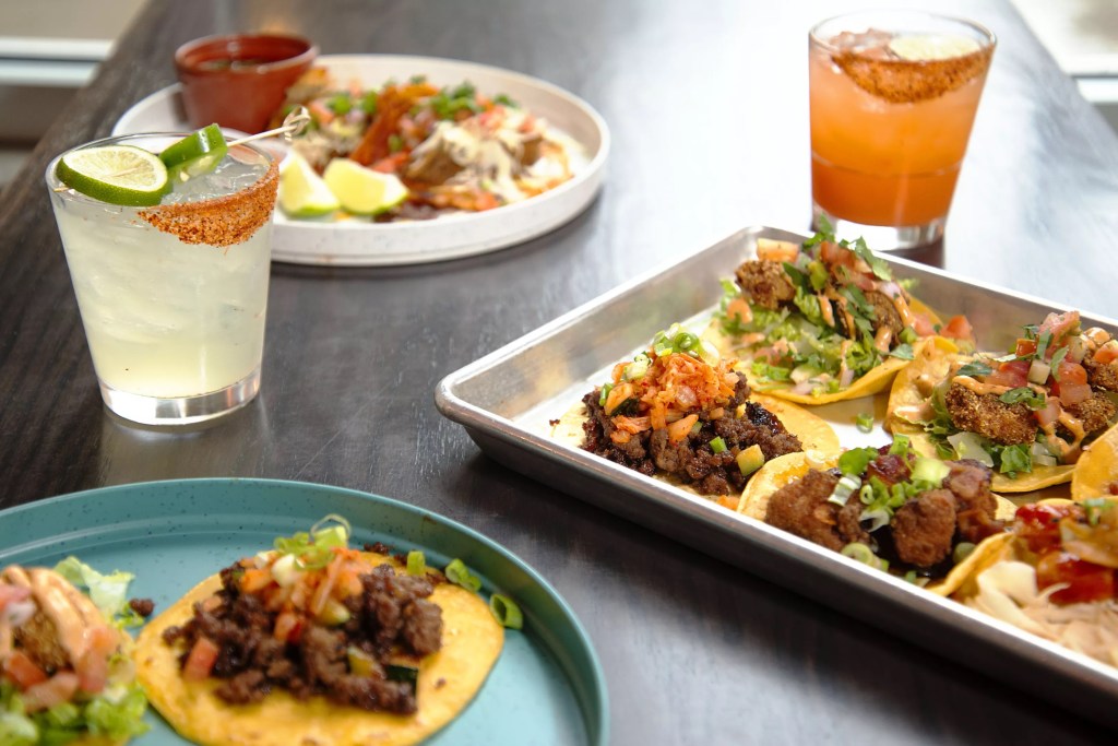 Plates of Korean-Mexican fusion tacos and margaritas from Wild Taco