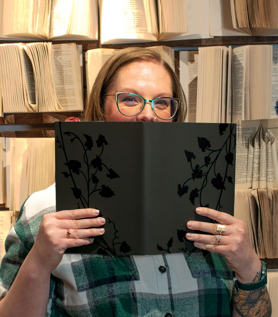 A woman holds a book in front of her face