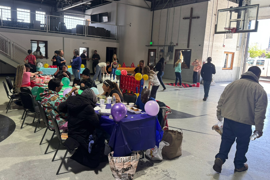 homeless people and children enjoy a meal inside of the Denver Dream Center in downtown denver