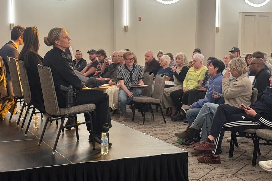 crowd listening to officials at meeting.