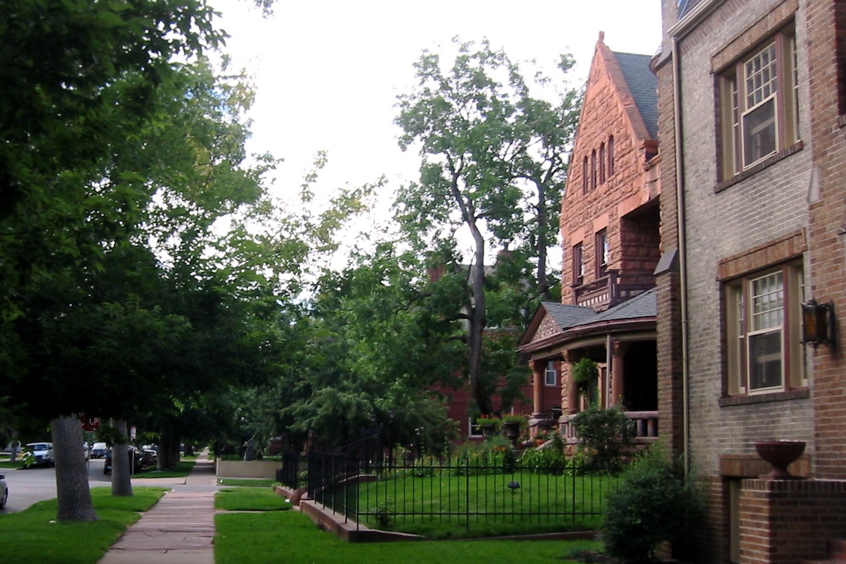 A row of old homes with lush lawns in east-central Denver