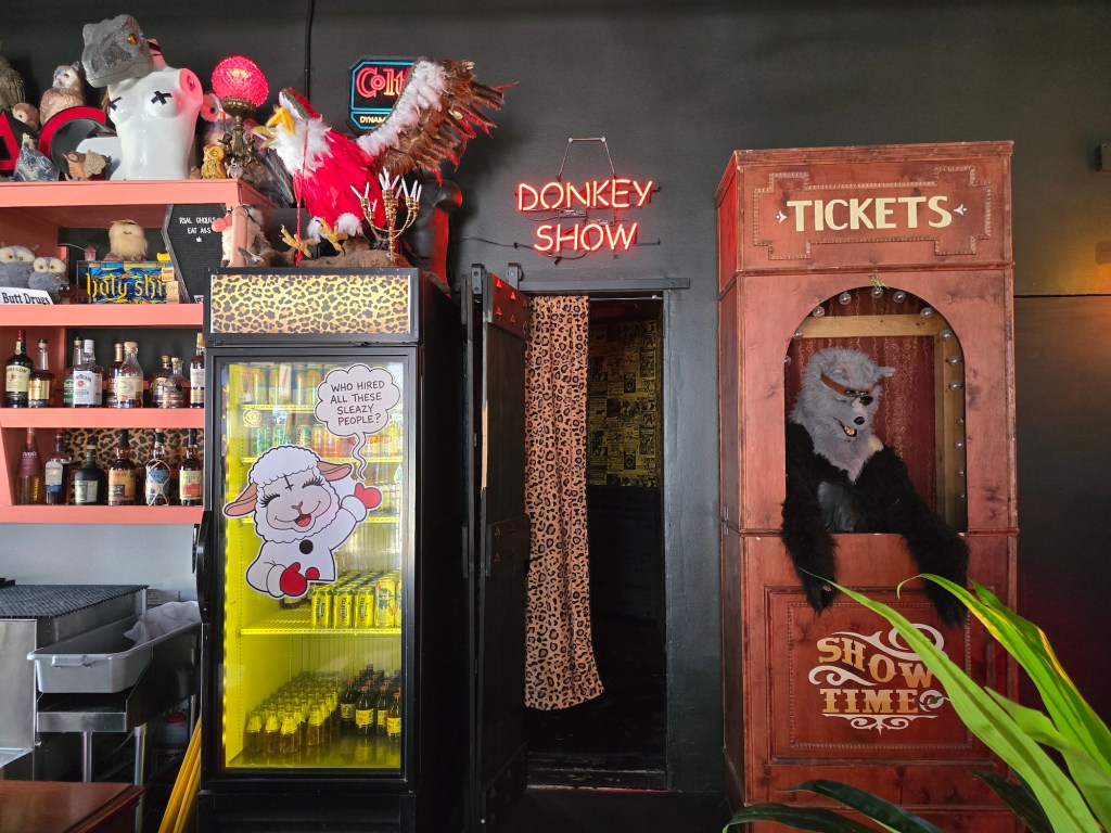 "Donkey Show" neon sign on a wall