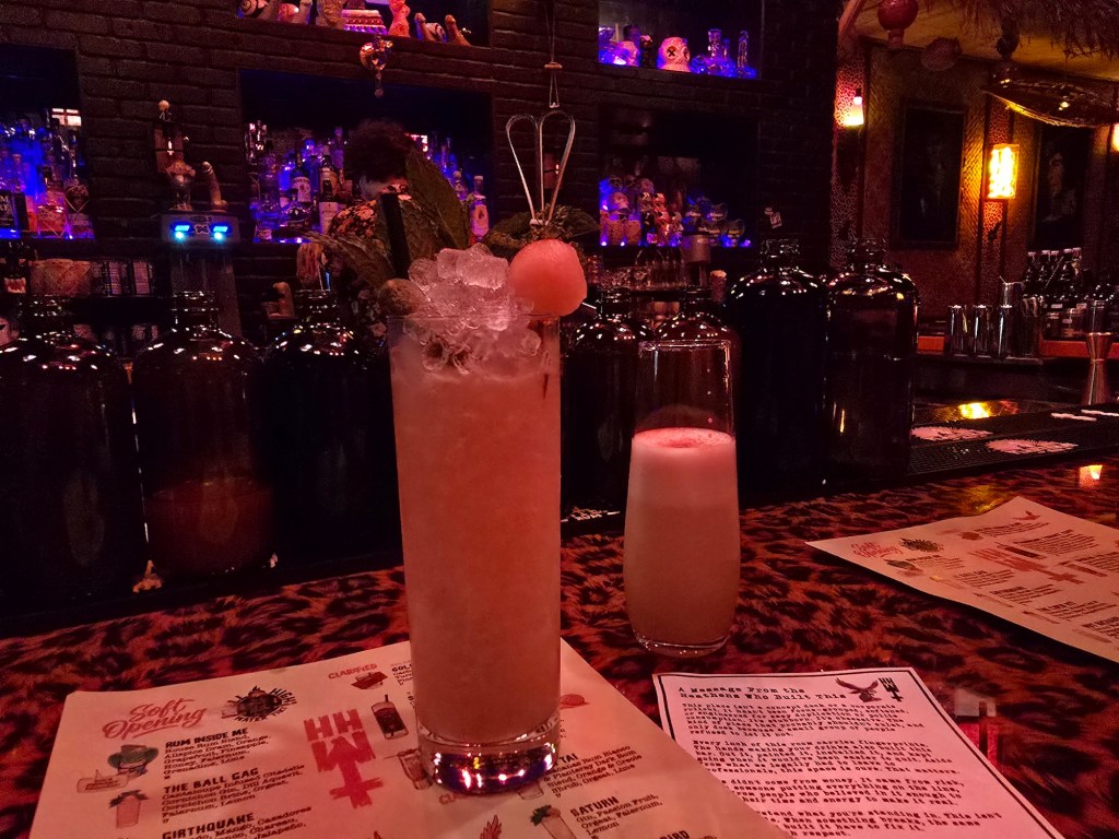 two tiki cocktails on a bar