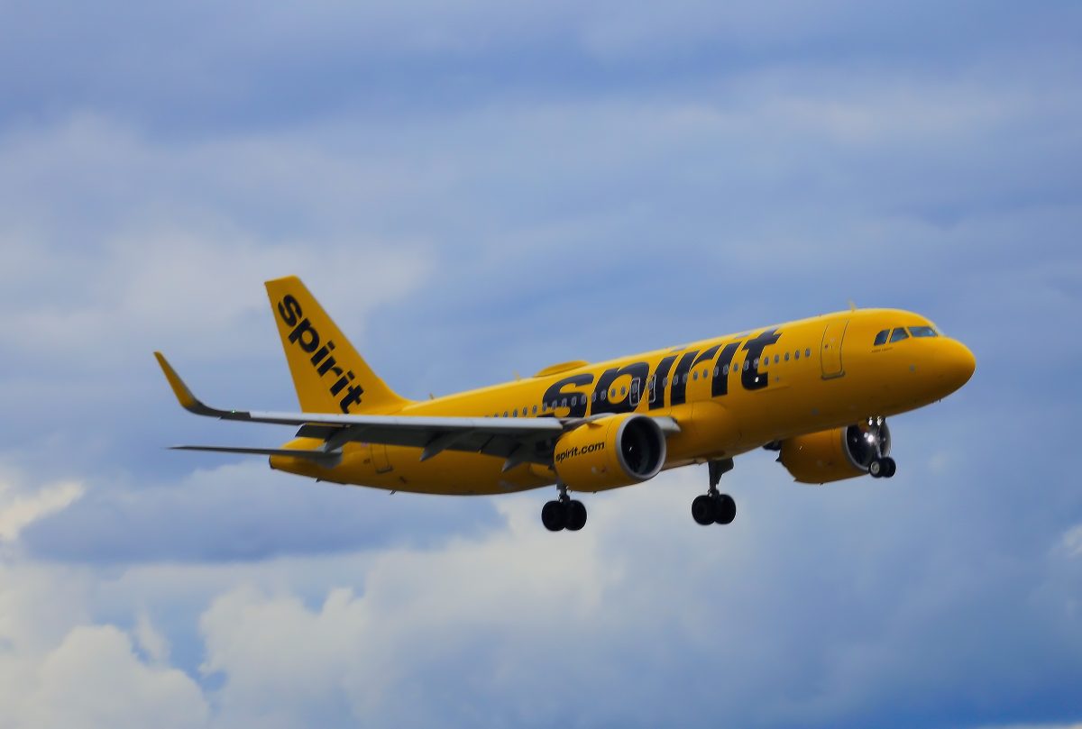 A yellow Spirit Airlines plane flies through the sky