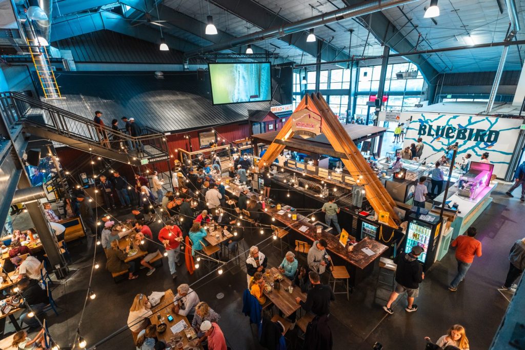 People dining at tables and along the bar inside Bluebird Market