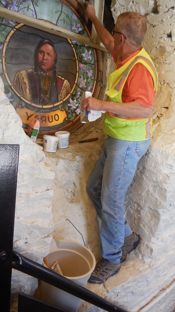 Phil Watkins working on repairs of the window  depicting Chief Ouray in the Hall of Fame Rotunda. 