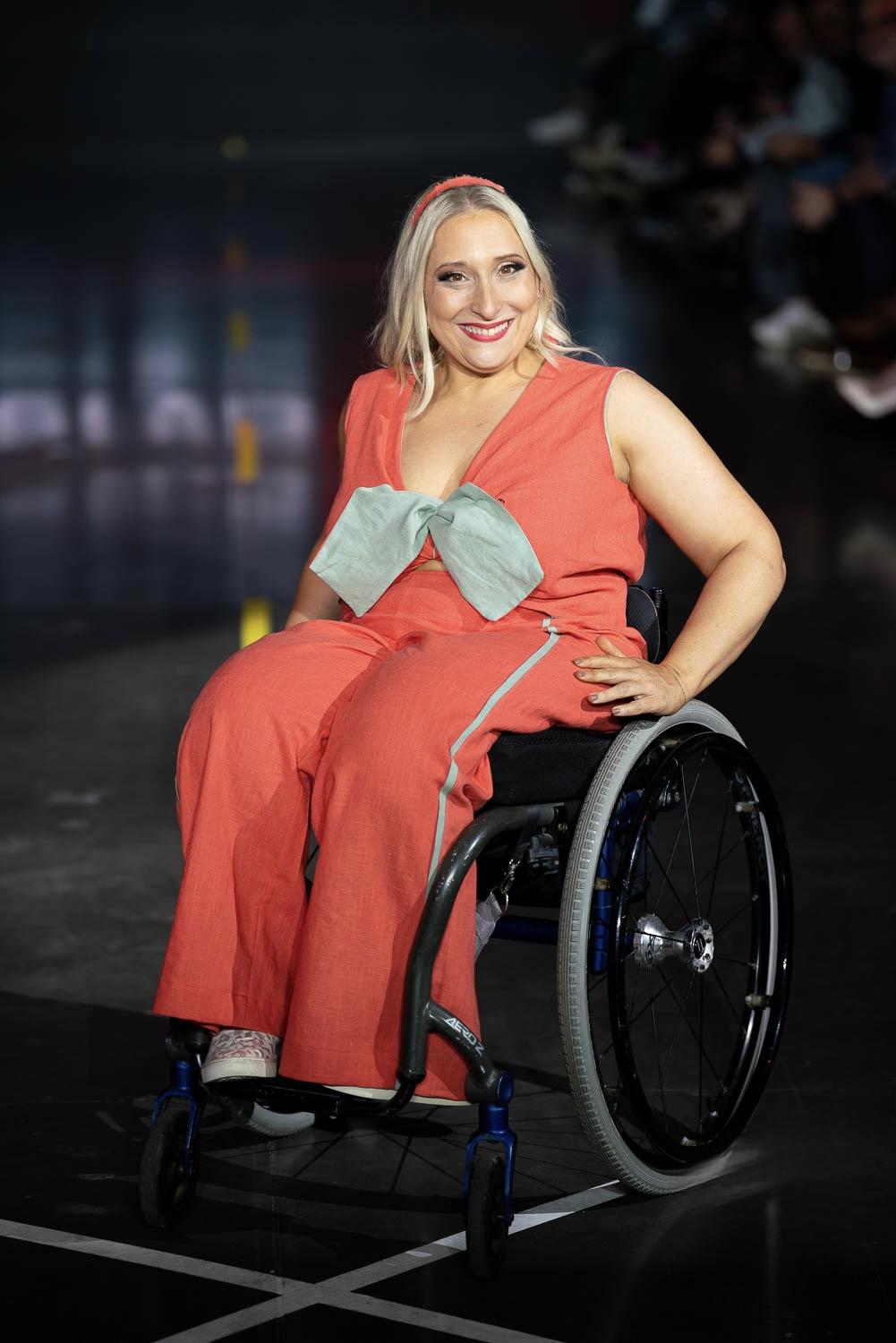 A model in a wheelchair rolls down the runway at Denver Fashion Week