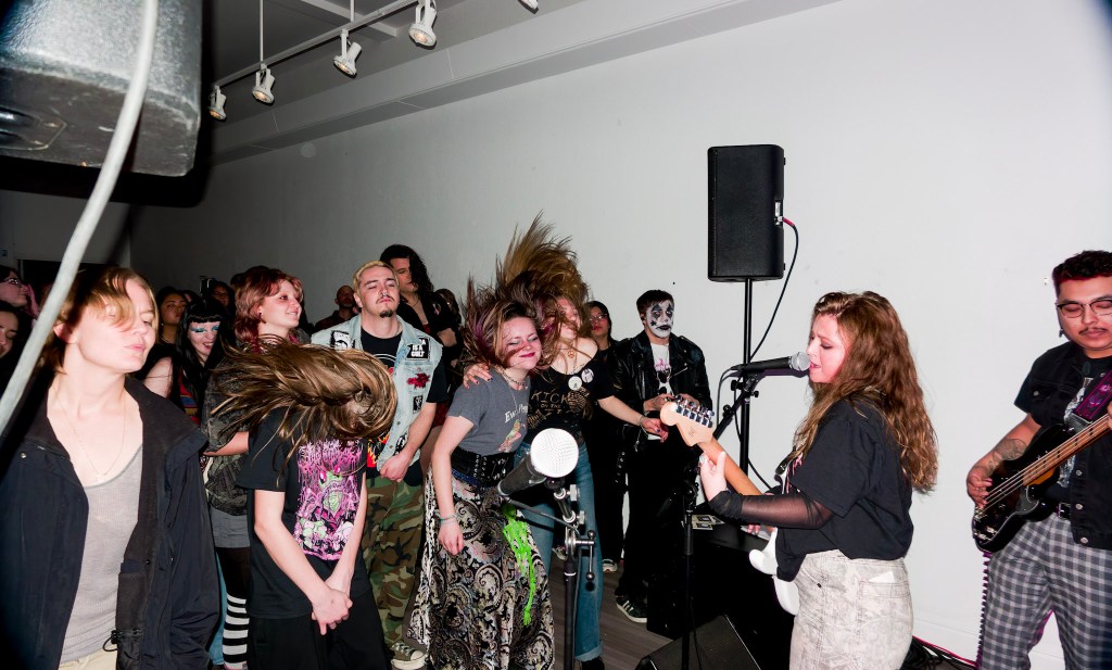A band playing with people moshing