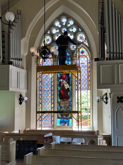 Repairing a window at Evans Memorial Chapel.