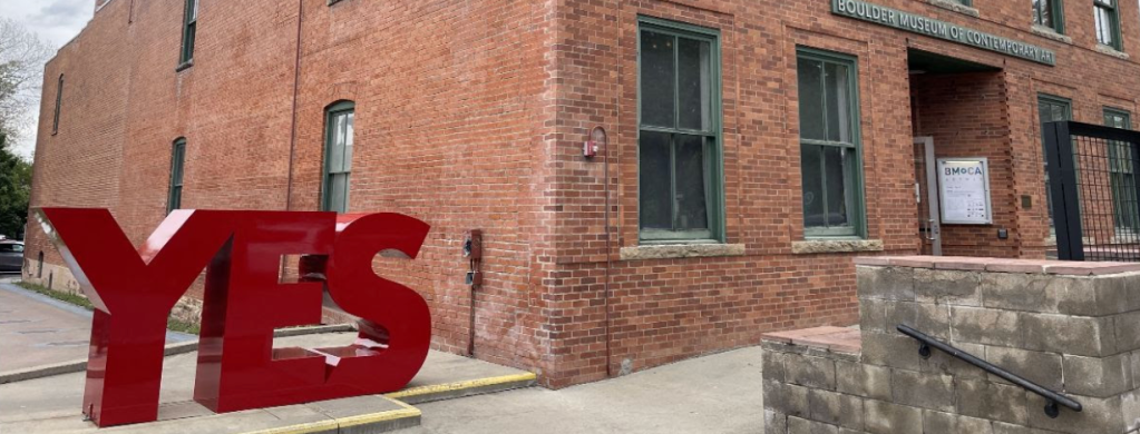 A red sculpture reaading "YES."