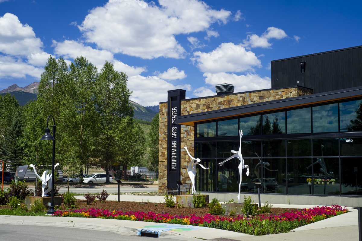 The modern exterior of the Silverthorne Performing Arts Center, featuring dancing sculptures
