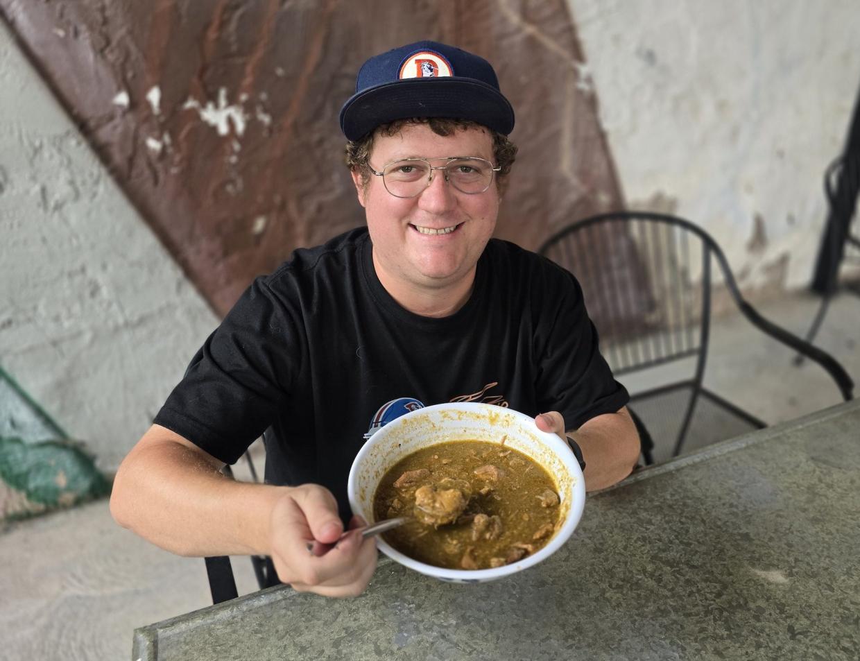 man holding bowl of green chile