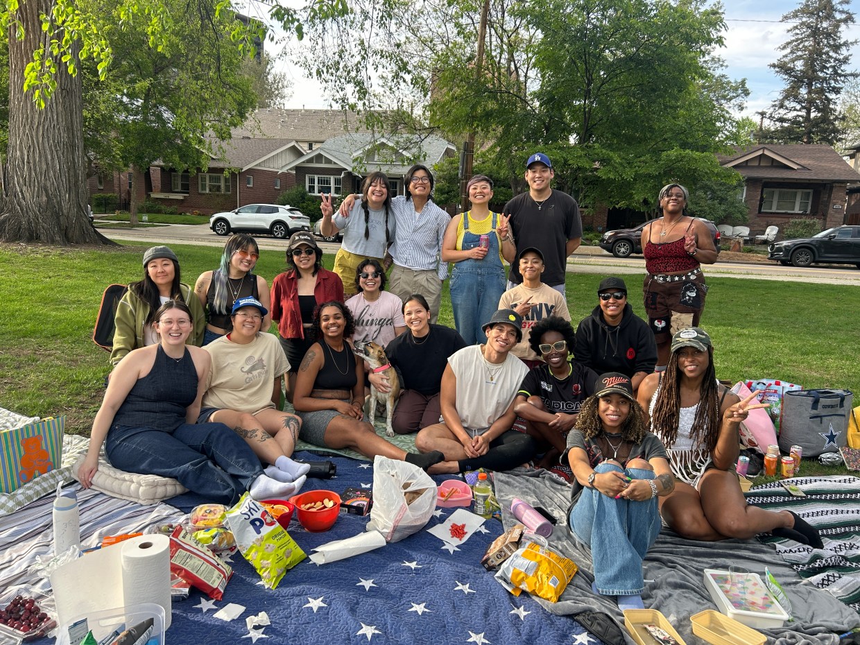 people take a group picture at a picnic