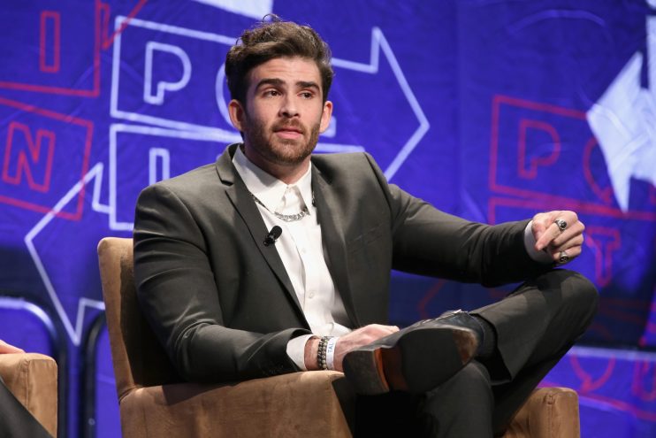 Hasan Piker sits on a panel during a political conference