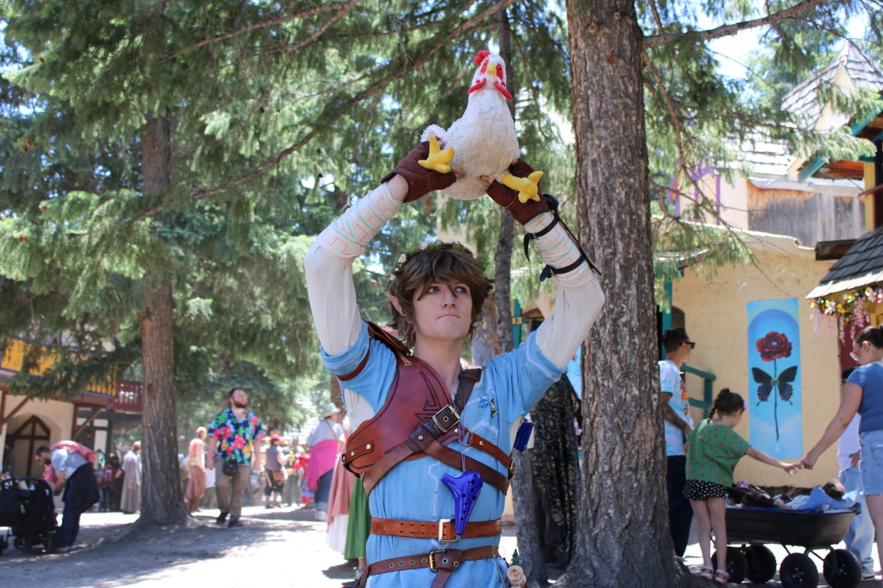 A man dressed as Link holds a chicken