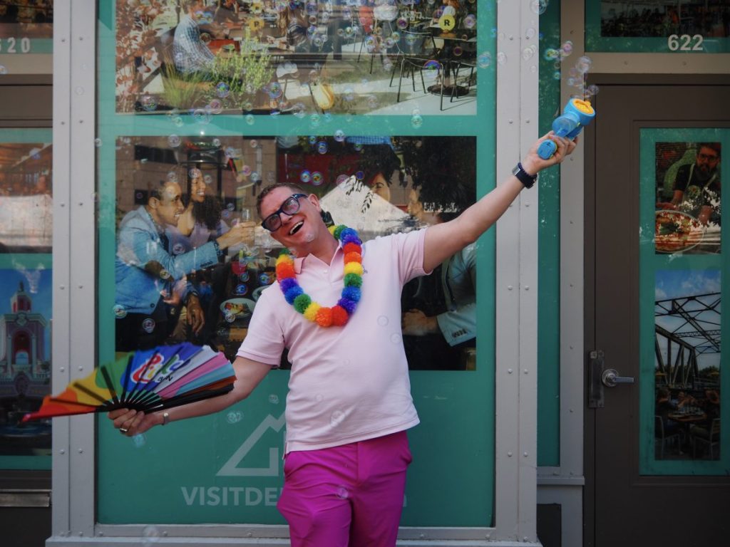 A man with a fan and bubble blower