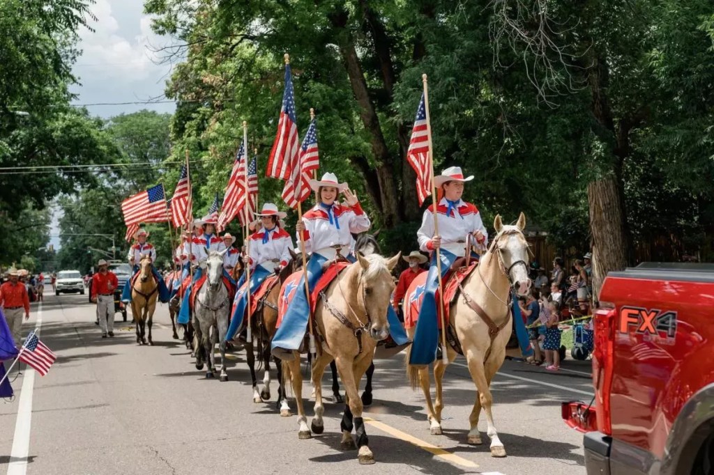 An equestrian unit holding American flags during the Park Hill Parade