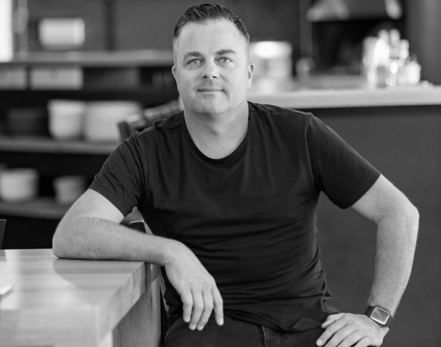 black and white head shot of man in black t shirt