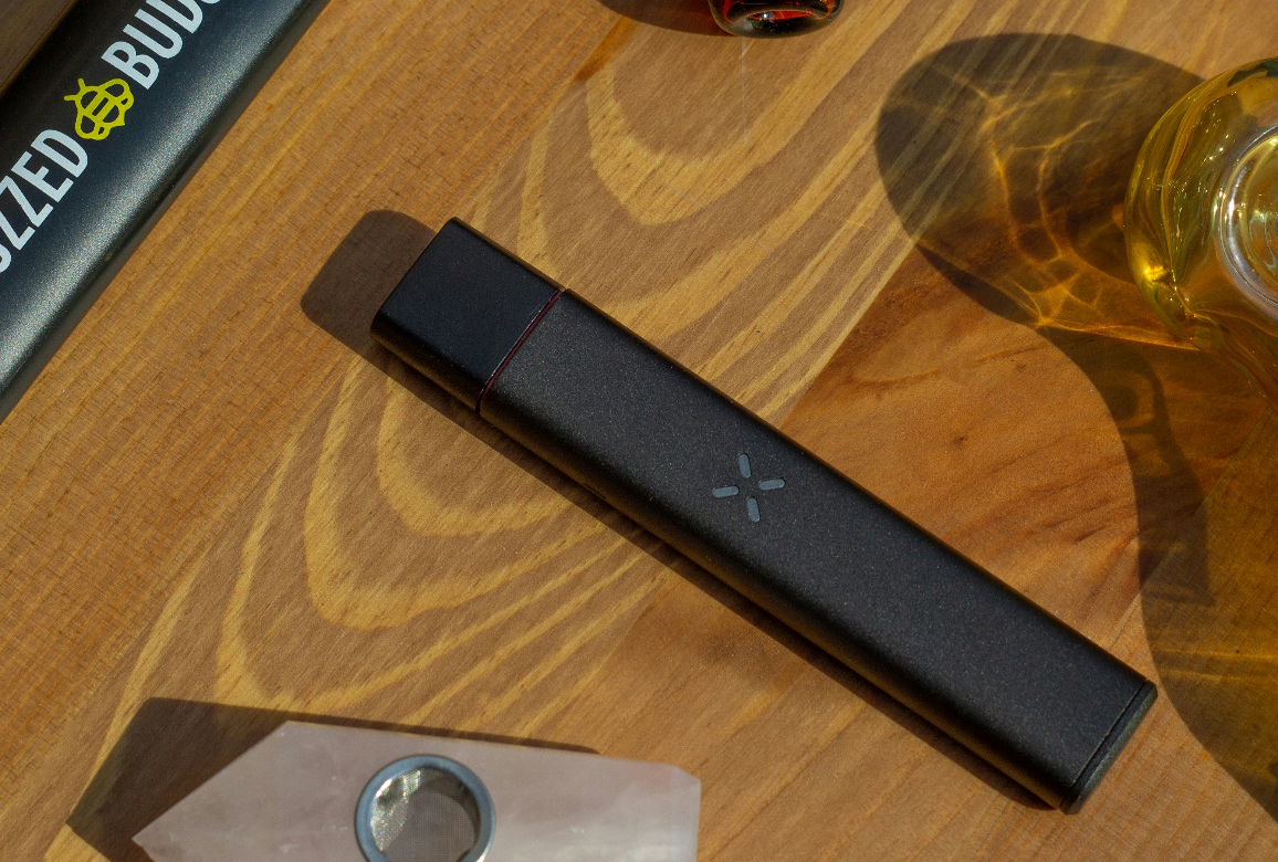 A Pax Era vape pen sits on a table