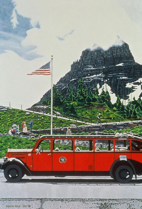 A red vehicle drives past a mountain