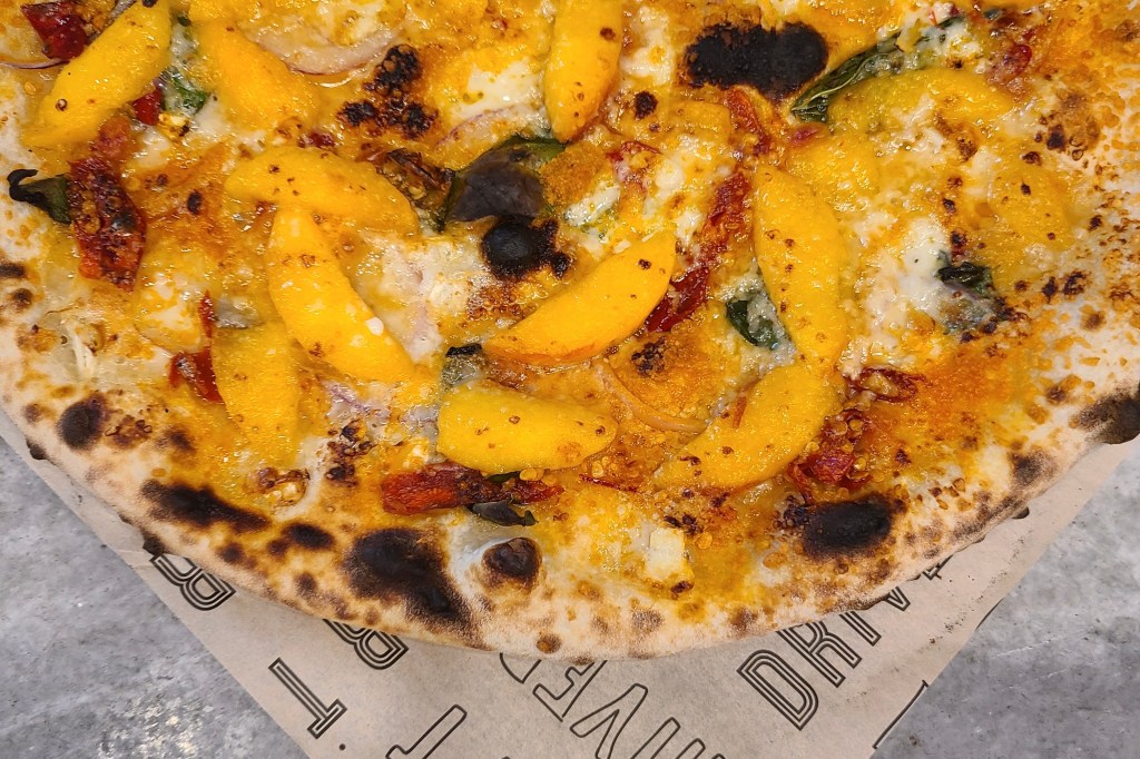 A wood-fired peach pizza
