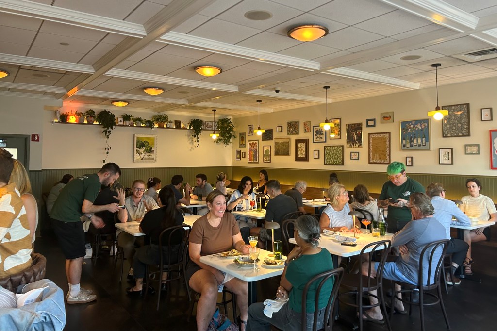 Guests in the Mother Other dining room featuring a gallery wall and live plants