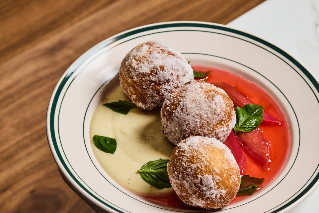 Three sugar-dusted brioche doughnuts served with vanilla custard and poached rhubarb