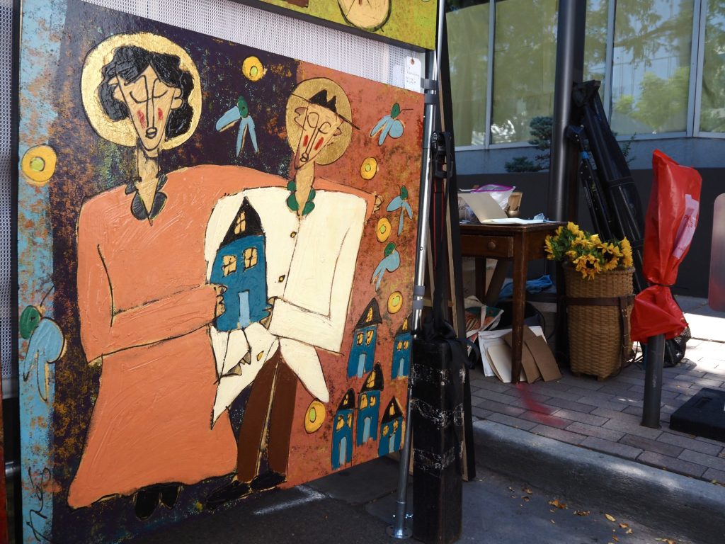 A painting of people holding a house