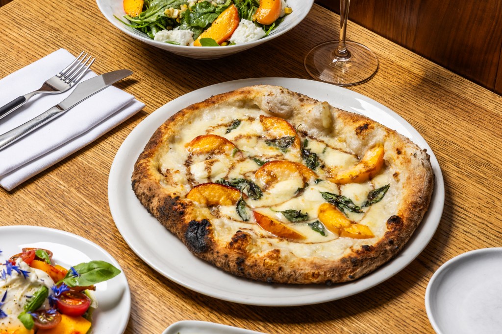 A peach pizza with mozzarella and basil