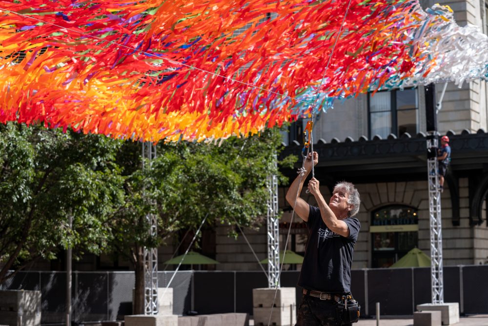 Patrick Shearn, artistic director of Colorado-based art studio Poetic Kinetics, works on the "Sun Splash" "Skynets" installation at Union Station.