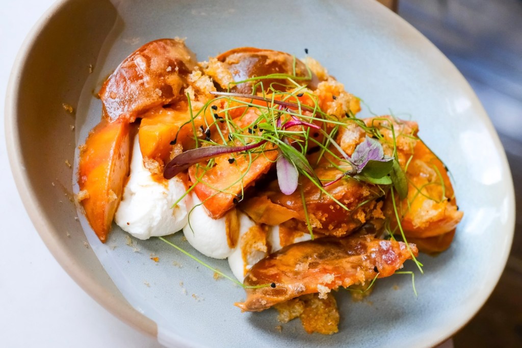 A peach and tomato salad with whipped ricotta