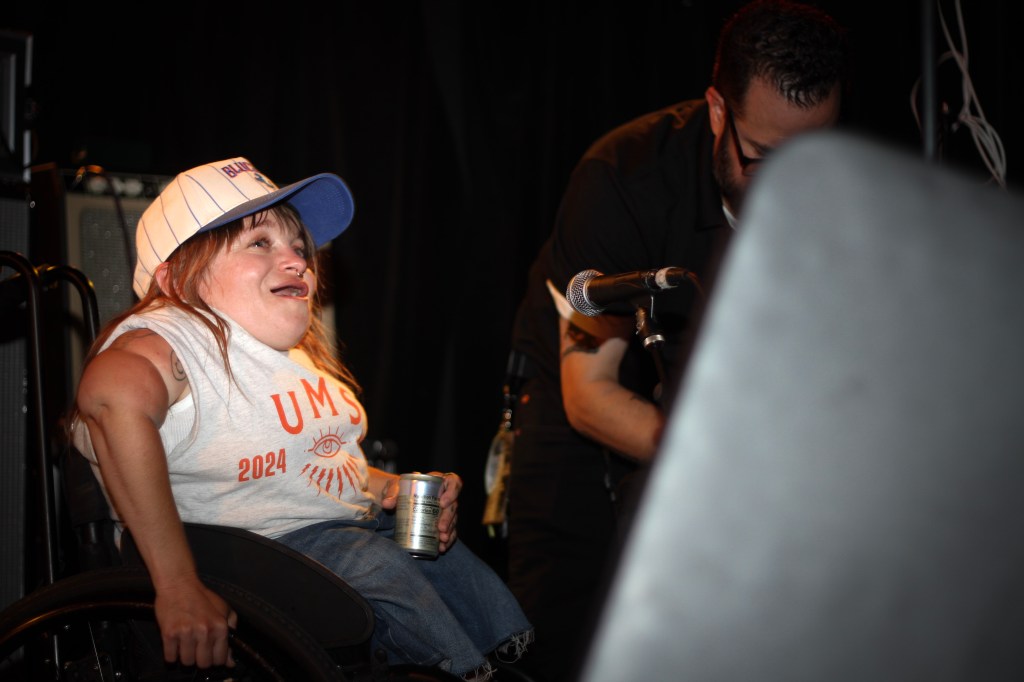 Kalyn Heffernan of Wheelchair Sports Camp is on stage preparing for a set at hi dive.
