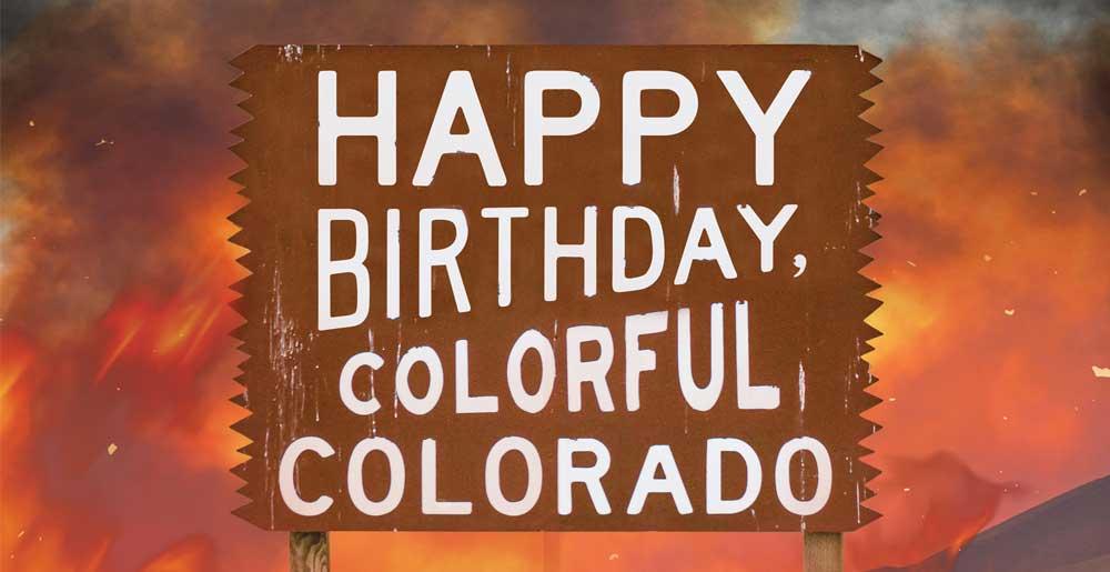 Colorful Colorado welcome sign as fire burns in the backgound