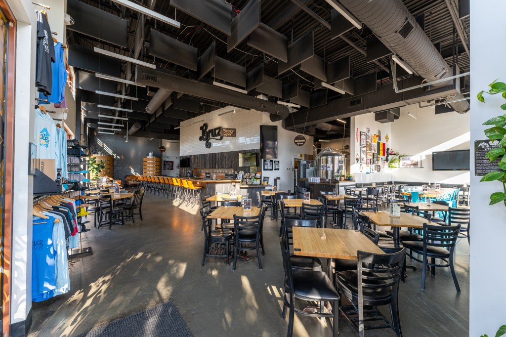 Interior of a brewery with bar and tables.