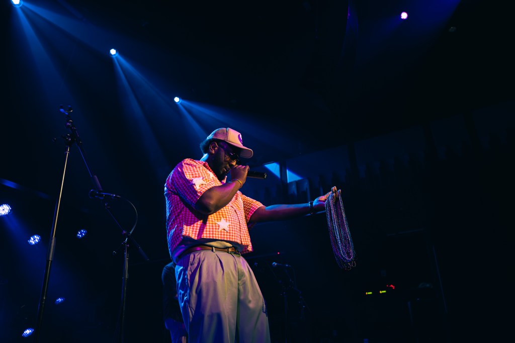 Artist DVNEHPPY holding Mardi Gras beads and microphone