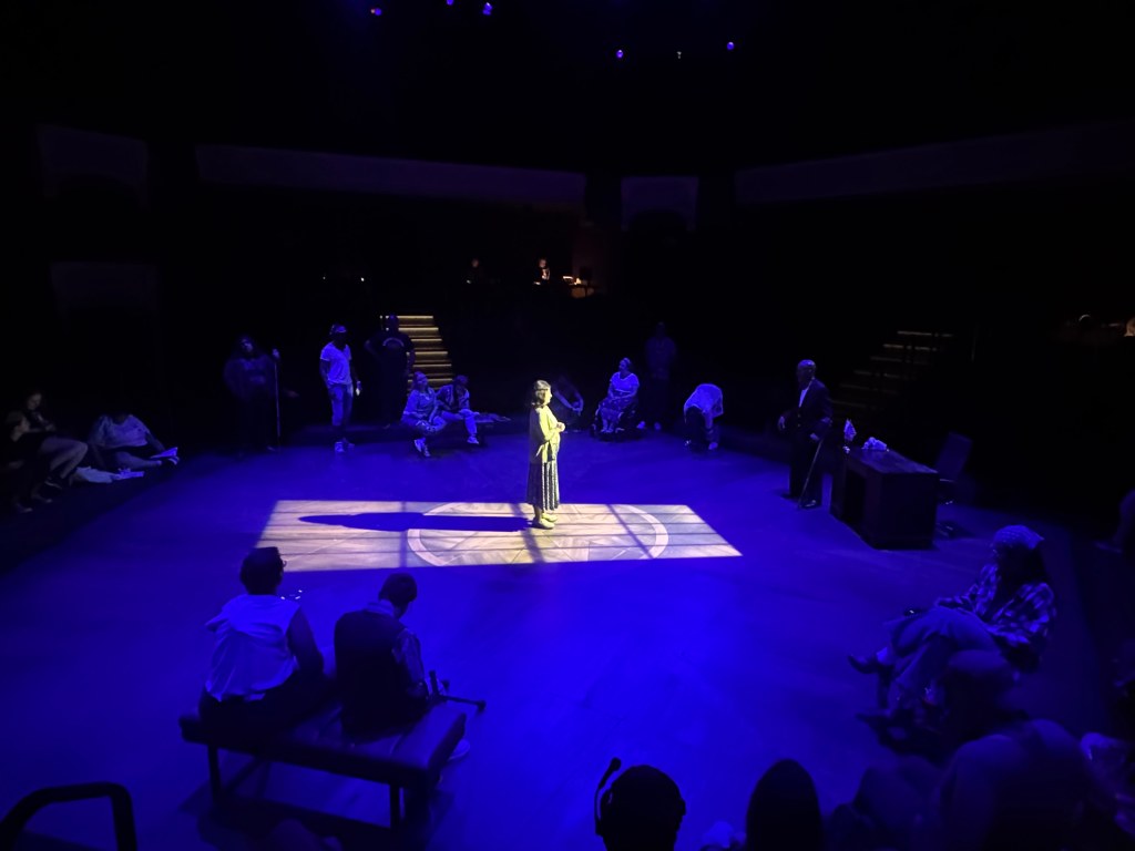A person stand center stage with light shone on them
