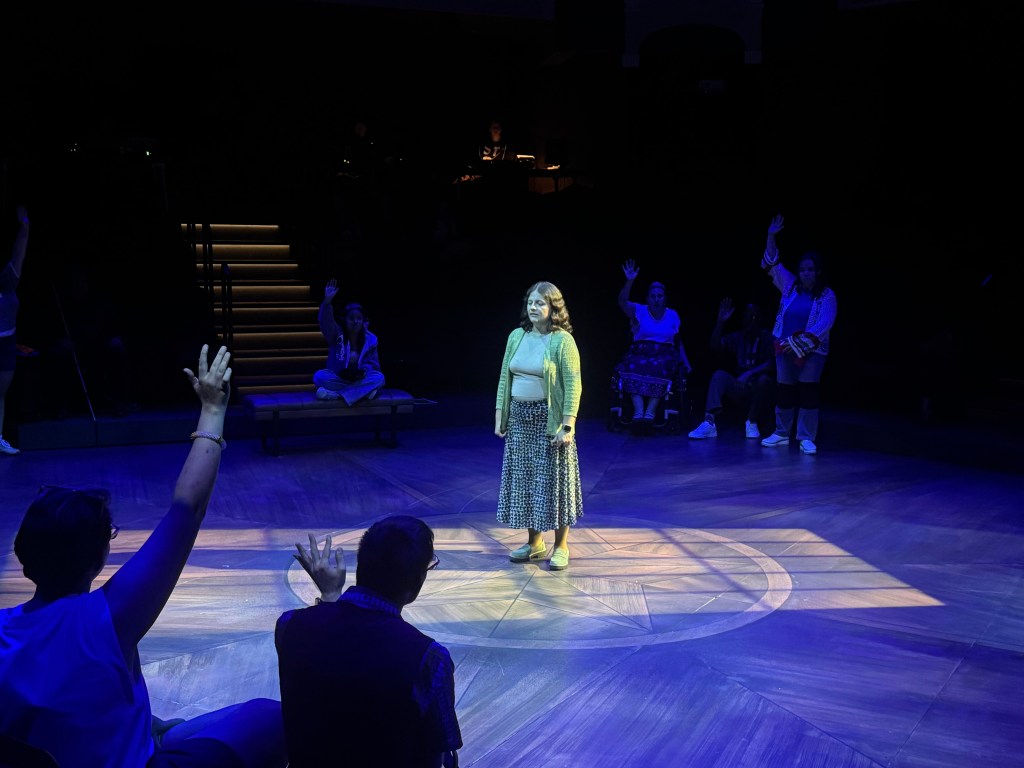 A person stands on a stage in light