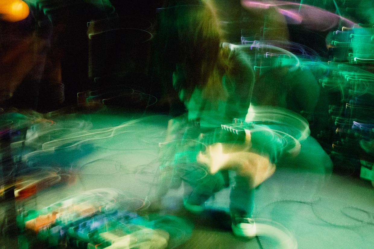 a blurred-out picture of a guitar player and their pedal board